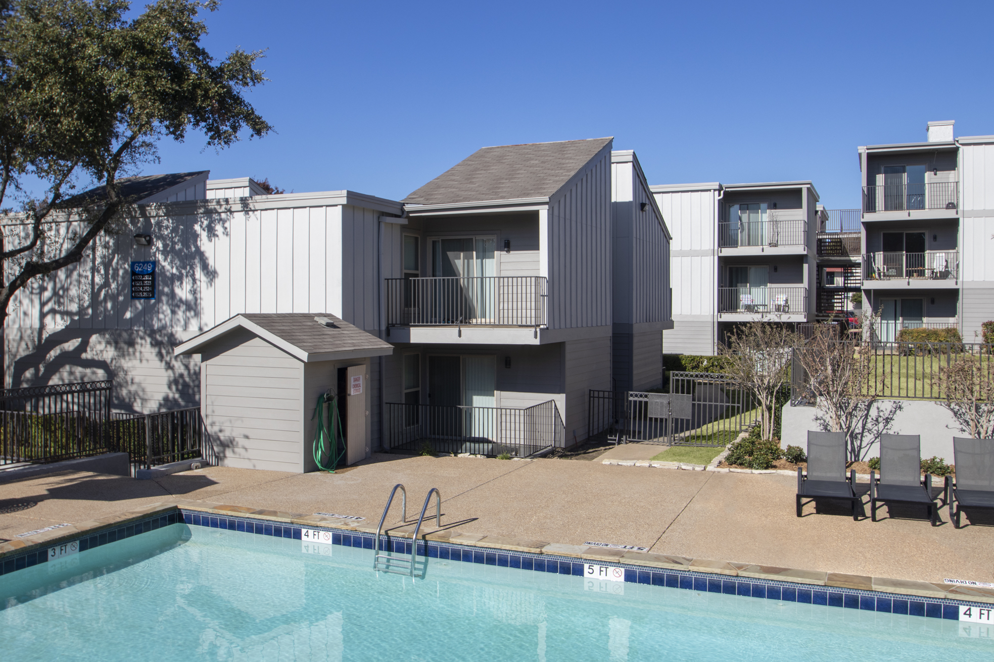This is a photo of the pool area and apartment exteriors at The Biltmore Apartments in Dallas, TX.