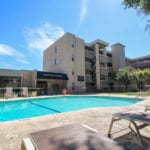 This is a photo of the pool area and courtyard at Harvard Square Apartments in Dallas, TX.